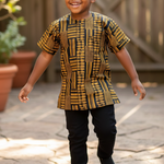 Child wearing a patterned Kente dashiki shirt and black pants outdoors