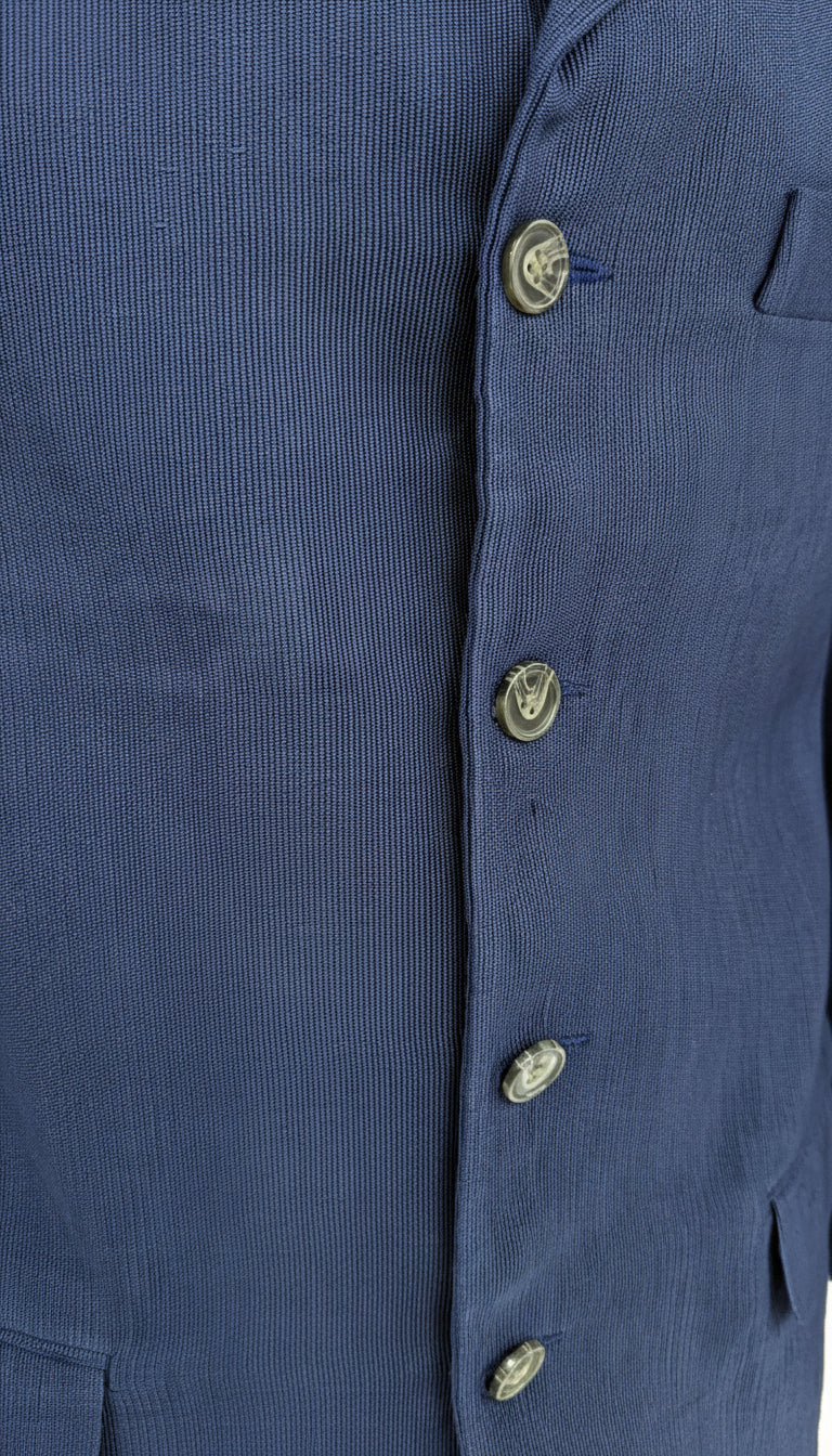 Close-up of a blue Aso Oke jacket with buttons on a white background