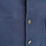 Close-up of a blue Aso Oke jacket with buttons on a white background