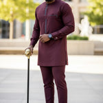 Man in burgundy traditional African outfit with a cane outdoors from Dupsie's African fashion
