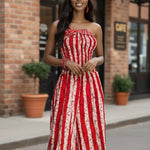 Red and white tie-dye batik wide-leg jumpsuit dress with smocked bodice, halter ties, and side pockets by Dupsie’s African Fashion.