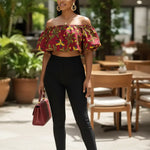 Model wearing a red, yellow, and green African-inspired print cropped blouse with off-the-shoulder puff sleeves.