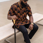 Front view of Jude black African shirt for men featuring repeating golden-orange lion-head motifs