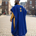 Dupsie’s African fashion showcasing Niyi Agbada robe in a traditional setting.