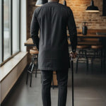Nigerian men's embroidered kaftan style Senator outfit in black silk cotton blend with silver embroidery.