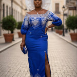 Nnkechi royal blue shimmery African George fabric dress with white embroidered neckline and three-quarter sleeves.