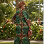 Woman wearing Toripe Boubou Dress in a lush outdoor setting.
